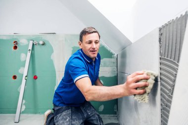 Ciddi profesyonel tiler duvara büyük format fayanslar kuruyor. ev dekorasyonu. 