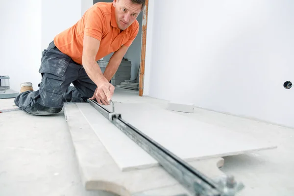 Handwerker Schneidet Keramikfliesen Mit Handlicher Maschine Auf Der Baustelle Innenbereich — Stockfoto