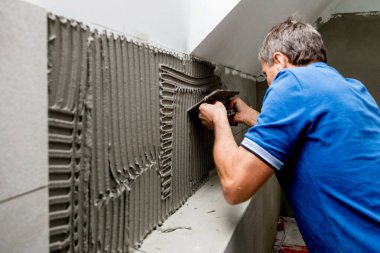 Profesyonel tiler duvara fayanslar yerleştiriyor. ev dekorasyonu.