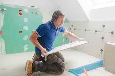 Tiler duvara büyük formatta karo yükler. ev kapalı yenileme