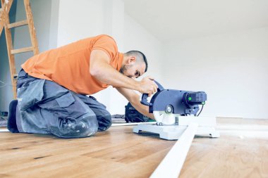 İnşaat alanında etek kesen işçiler. Parke döşeme