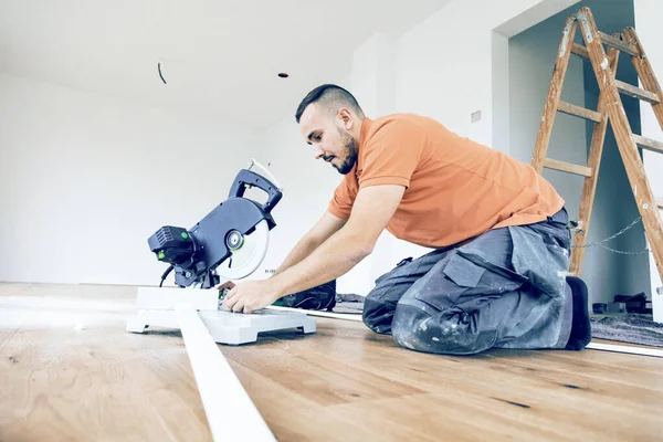 Worker Cutting Skirting Boards Construction Site Lay Parquet Floor — Stock Photo, Image