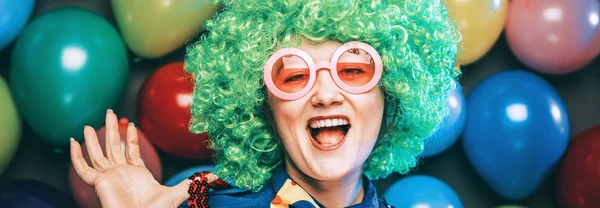 portrait of beautiful happy woman in wig and glasses having fun at party