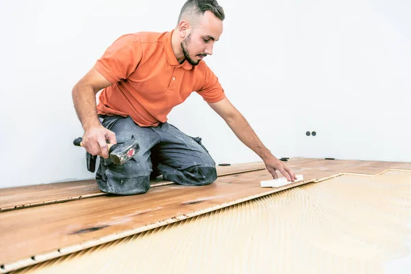 建筑工地上的年轻男工 铺花篮地板 — 图库照片