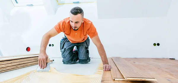 Arbeiter Verlegt Parkettboden Auf Baustelle — Stockfoto