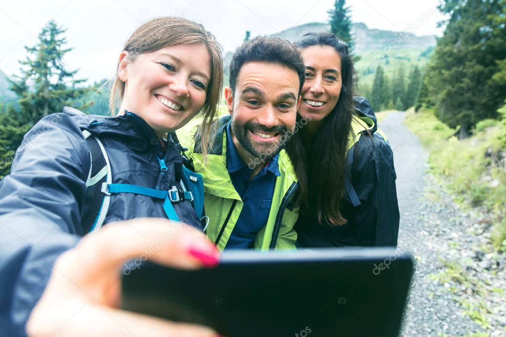 Hiking friends standing on mountain terrain taking a selfie on a foggy day