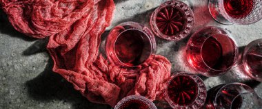 close-up view of glasses of red wine on grey background