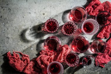 close-up view of glasses of red wine on grey background