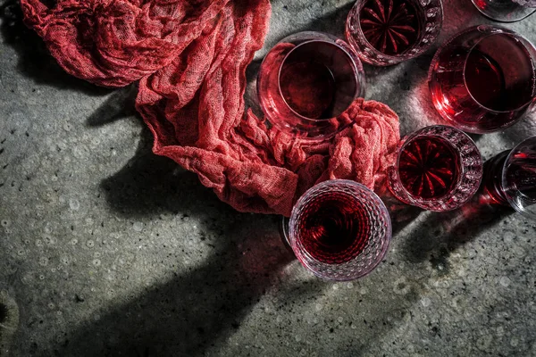 top view of glasses of red wine on gray background