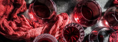 close-up view of glasses of red wine on grey background