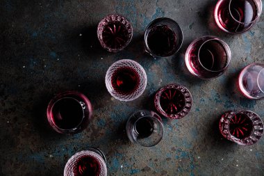 top view of glasses of red wine on grey background