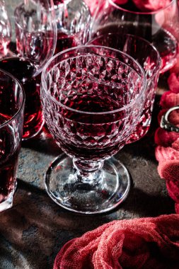 close-up view of glasses of red wine on grey background