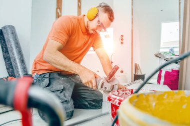 Erkek işçi inşaat alanında çalışıyor. Parke döşeme