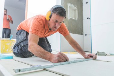 professional tilers installing large format tiles. home indoors renovation clipart