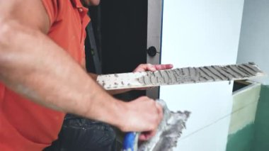 Adam duvara büyük formatlı fayanslar yerleştiriyor. konut yenileme konsepti