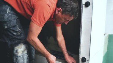 Adam duvara büyük formatlı fayanslar yerleştiriyor. konut yenileme konsepti