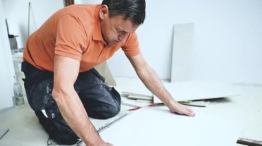 Adam duvara büyük formatlı fayanslar yerleştiriyor. konut yenileme konsepti