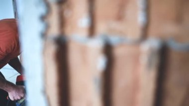 Adam duvara büyük formatlı fayanslar yerleştiriyor. konut yenileme konsepti