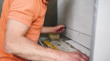 Adam duvara büyük formatlı fayanslar yerleştiriyor. konut yenileme konsepti