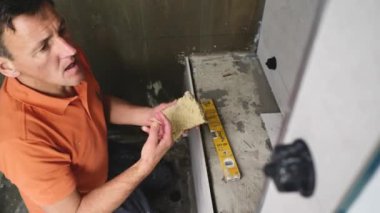 Adam duvara büyük formatlı fayanslar yerleştiriyor. konut yenileme konsepti