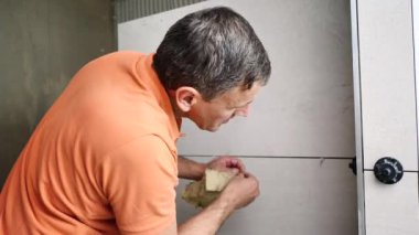 Adam duvara büyük formatlı fayanslar yerleştiriyor. konut yenileme konsepti