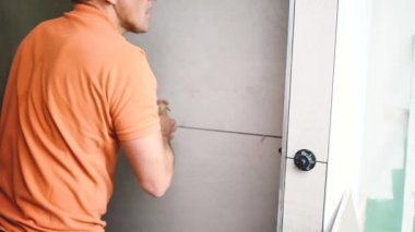 Adam duvara büyük formatlı fayanslar yerleştiriyor. konut yenileme konsepti