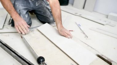 İnşaat alanında kullanışlı makineyle fayanslar kesen adam.