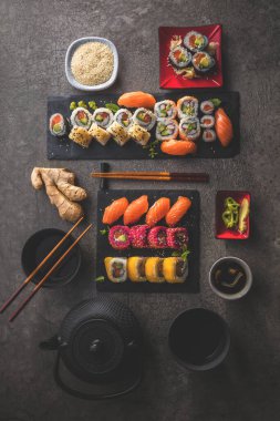 Yemek çubuklarıyla tahtaya dizilmiş lezzetli suşi manzarası.