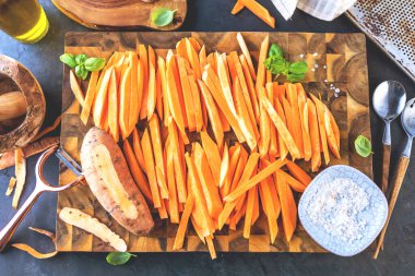 Tahtada organik dilimlenmiş tatlı patateslerin üst görüntüsü.  