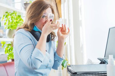 Tıbbi maskeli ve koruyucu gözlüklü hasta genç bir kadın.