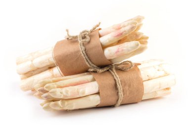 Beyaz arka planda izole edilmiş taze organik kuşkonmaz demetleri.