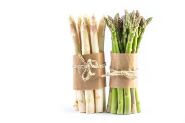 Beyaz arka planda izole edilmiş taze organik kuşkonmaz demetleri.