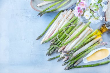 Mavi yüzeyde taze yeşil ve beyaz kuşkonmazın üst görüntüsü
