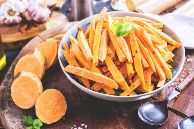 Masanın üzerinde dilimlenmiş tatlı patatesli kâse manzarası.