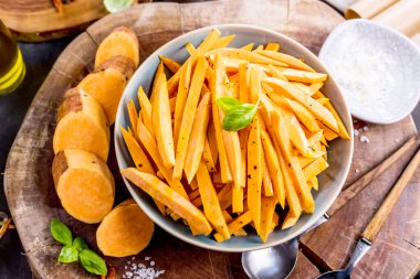 Lezzetli dilimlenmiş patates ve fesleğen yapraklı kase manzarası.