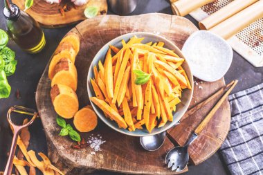 Lezzetli dilimlenmiş patates ve fesleğen yapraklı kase manzarası.