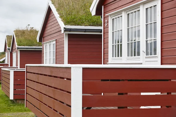 Tradizionali cabine in legno rosso norvegese con terra sul tetto — Foto Stock