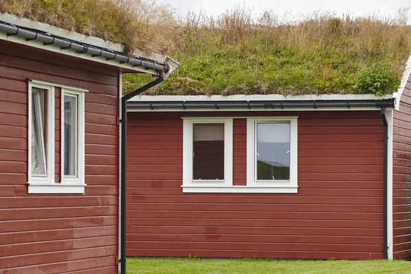 Traditional red wooden norwegian cabins with ground on the roof. — Stock Photo, Image