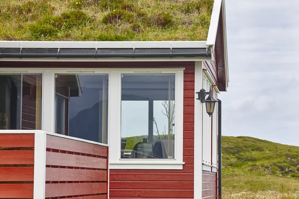 Traditionele rode houten Noorse hutten met grond op het dak. — Stockfoto