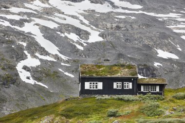 Siyah ahşap evi ile geleneksel Norveç dağ manzarası