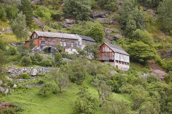 Maison traditionnelle en bois nordique sur un paysage verdoyant de collines forestières — Photo