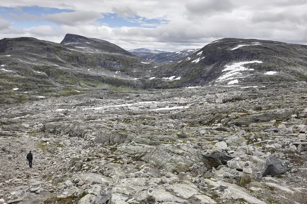 Paisagem montesa rochosa norueguesa com neve e caminhante. Noruega t — Fotografia de Stock