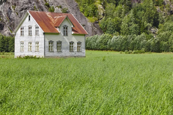 Norsk antik traditionelt træhus med græs og mounta - Stock-foto