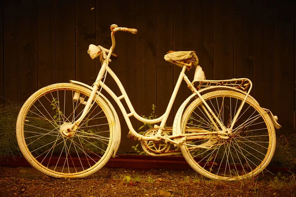 Weißes altes rostiges Fahrrad in warmem Goldton. Vorgeschichte. — Stockfoto