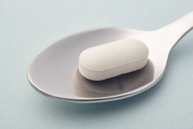 Hap ve kaşık ayrıntı. Mavi arka plan. İlaç tedavisi. O