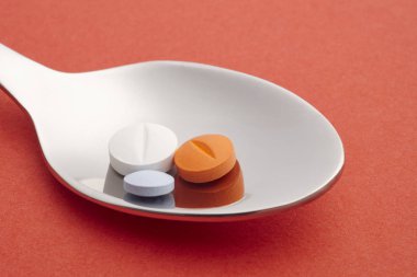 Hap ve kaşık ayrıntı. Kırmızı arka plan. İlaç tedavisi. O