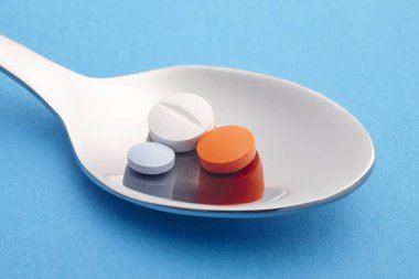 Hap ve kaşık ayrıntı. Mavi arka plan. İlaç tedavisi. H