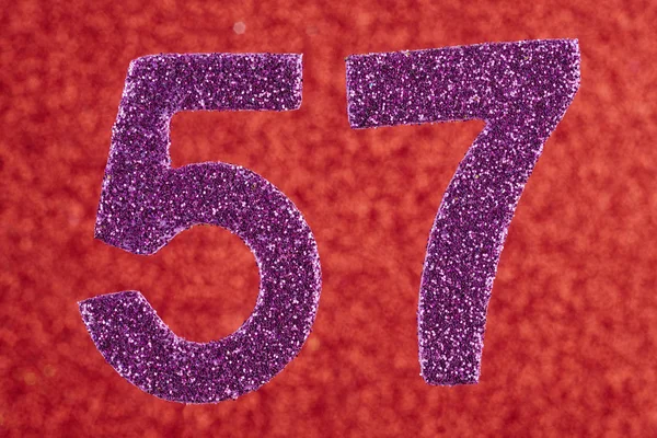 Número cinquenta e sete cor roxa sobre um fundo vermelho. Anniversa — Fotografia de Stock