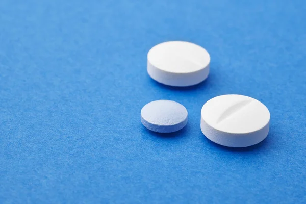 Pillole su sfondo blu. Trattamento farmacologico. Assistenza sanitaria — Foto Stock