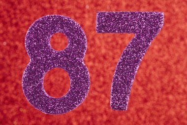 Seksen yedi mor renk kırmızı bir arka plan üzerinde numara. Annivers